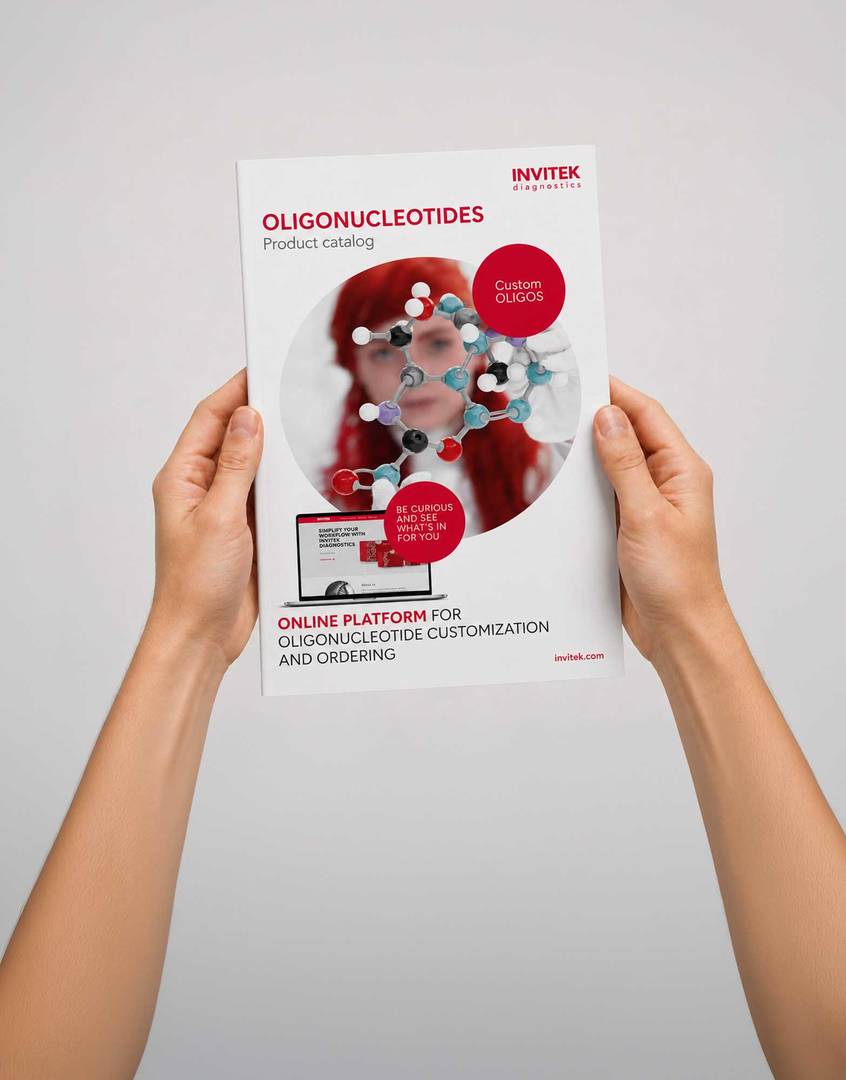 Hands holding an INVITEK Diagnostics catalog featuring a DNA helix image and molecular diagnostics branding on the cover.