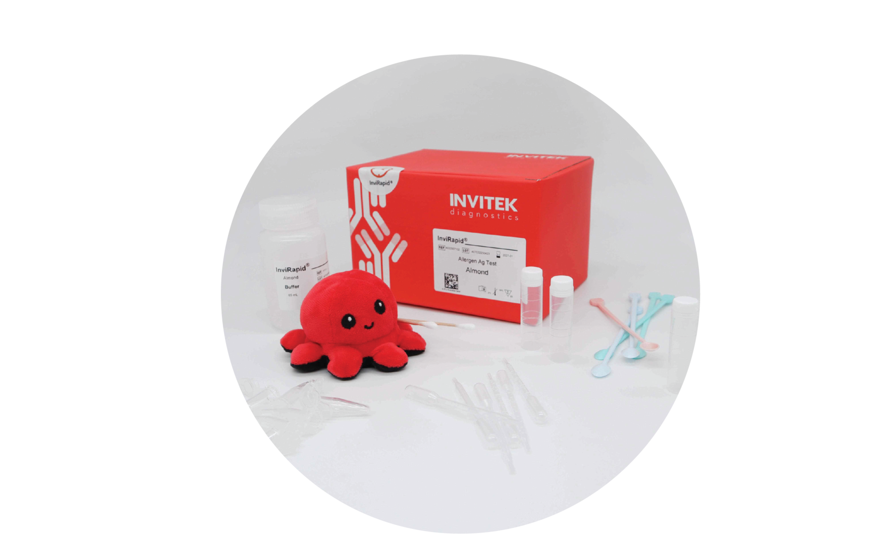 Red Invitek Diagnostics InviRapid Almond Allergen Ag Test box behind a buffer bottle and sample tubes with scoops, droppers, swabs, and tubes laying scattered in front.