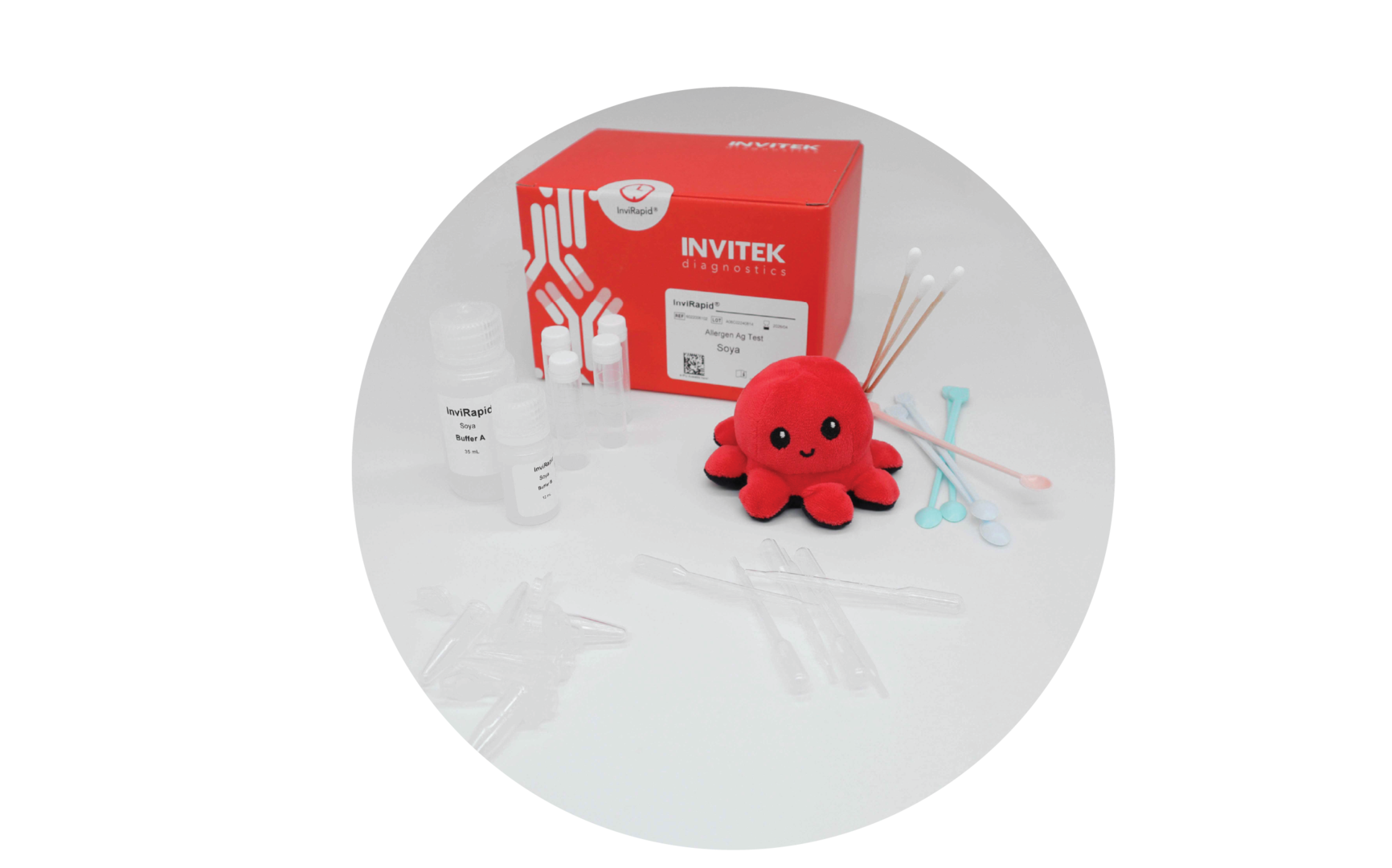 Red Invitek Diagnostics InviRapid Soya Allergen Ag Test box behind buffer bottles, sample tubes, and swabs with scoops, droppers and tubes laying scattered in front.