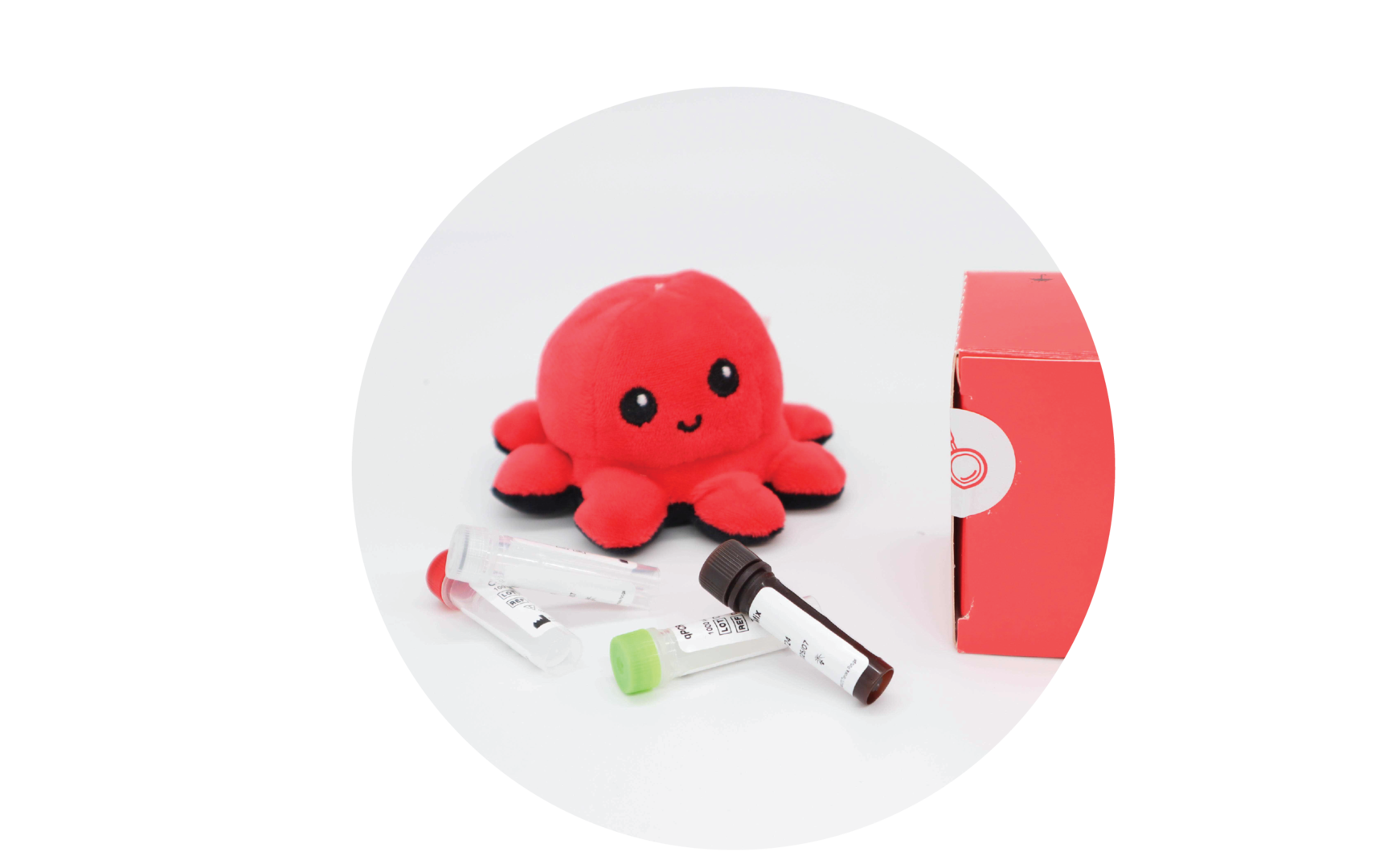 InviScreen SARS-CoV-2 4G kit: plush octopus beside red INVITEK box, with mixed reagent vials (clear, green, brown caps) lying in foreground.