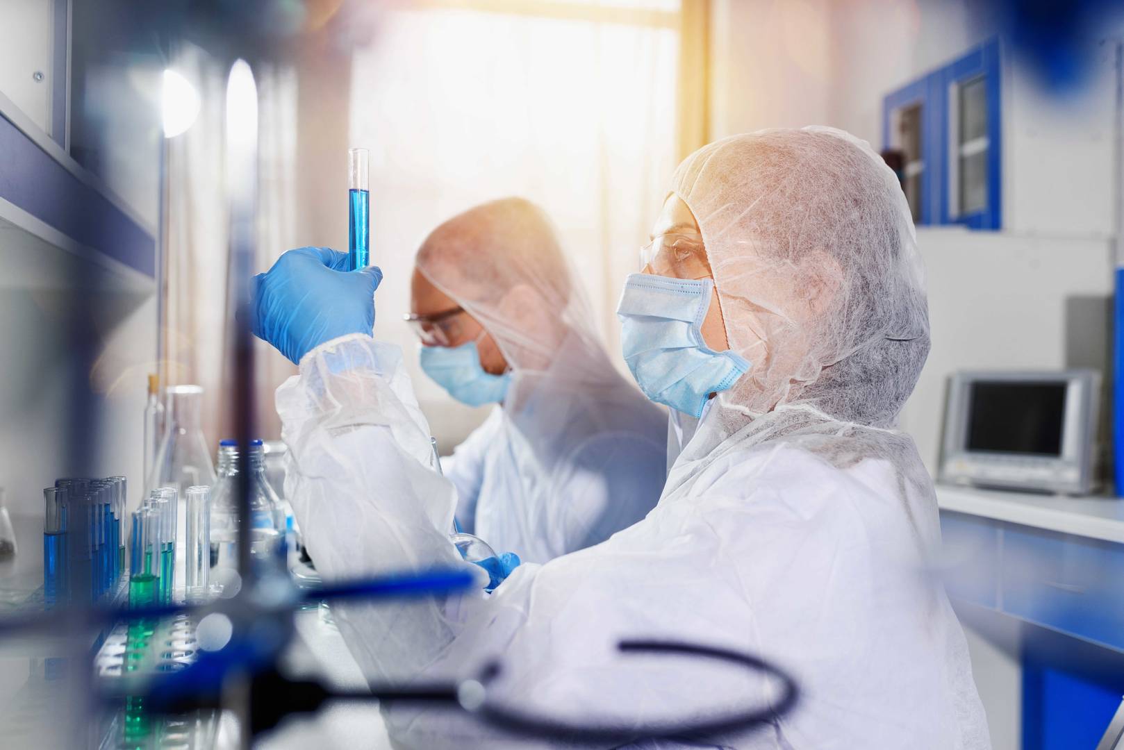 lab techs in ppe looking at samples